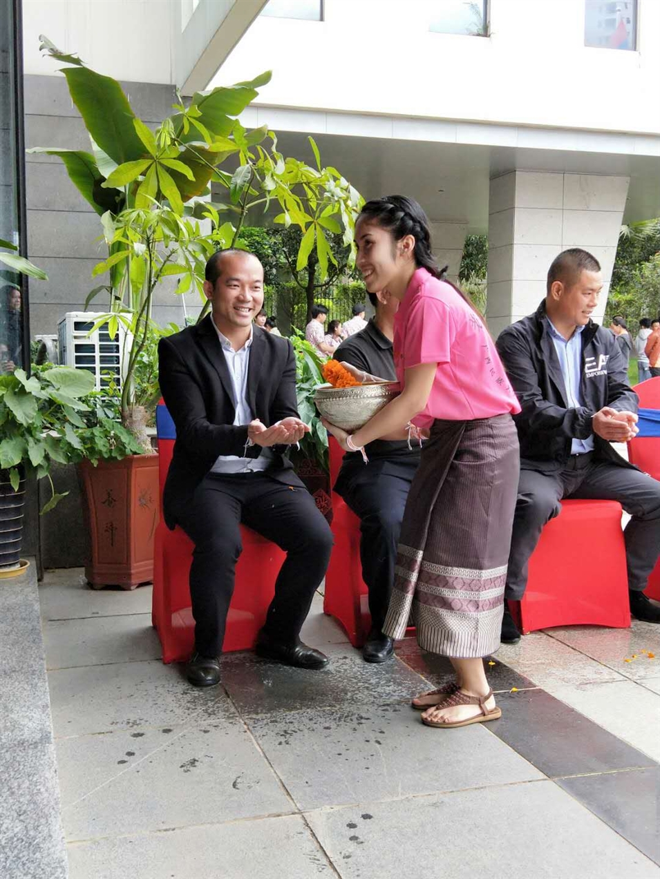 老撾駐廣西留學(xué)生代表將浸有花瓣的香水灑客人的手上，表示對(duì)嘉賓的美好祝福（圖一）
