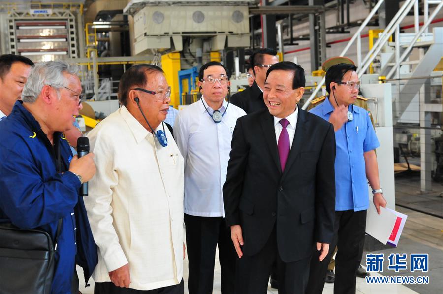 3月10日，在老撾沙灣拿吉省車邦縣，老撾人民革命黨中央總書記、國家主席本揚(yáng)（左二）在山東太陽紙業(yè)股份有限公司董事長李洪信（右二）的陪同下視察公司。 新華社記者章建華攝
