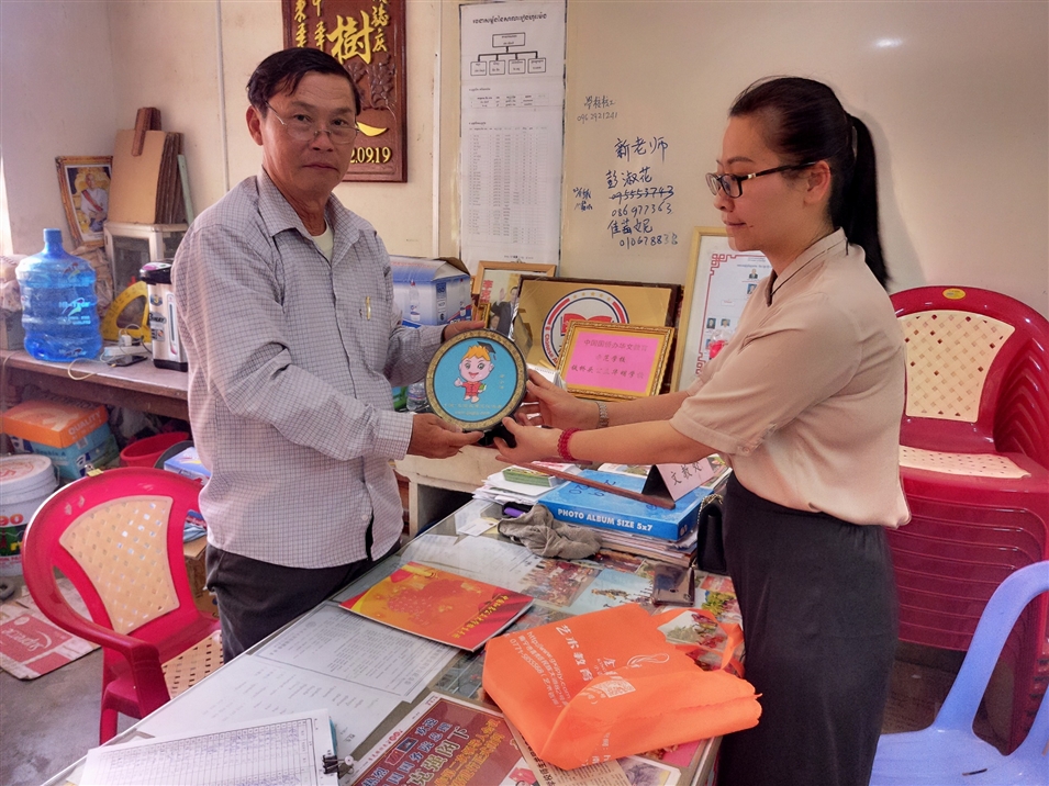 與華明學校文教處主任江源明合影留念